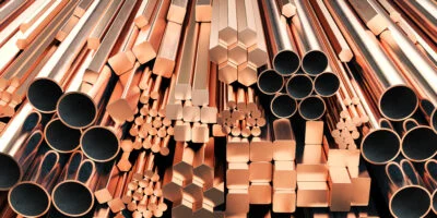 Copper tubes and different profiles in warehouse background Different copper metal rolled products